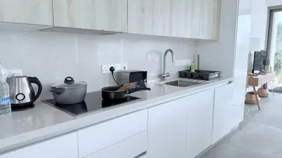 a white kitchen with a sink and a counter at TooCoool Villa - Azure Seaview in Protaras
