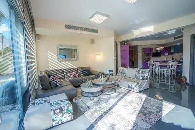 a living room with a couch and a table at Royal Nissi Mansion 3 bed lower part of villa in Ayia Napa