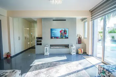 a living room with a fireplace and a tv at Royal Nissi Mansion 3 bed lower part of villa in Ayia Napa