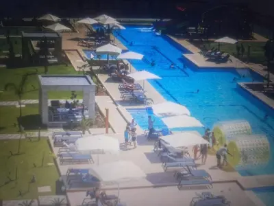 an overhead view of a swimming pool with chairs and umbrellas at Courtyard Holiday Resort Studio in Iskele