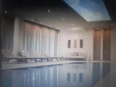 a swimming pool with chairs and a table and water at Courtyard Holiday Resort Studio in Iskele