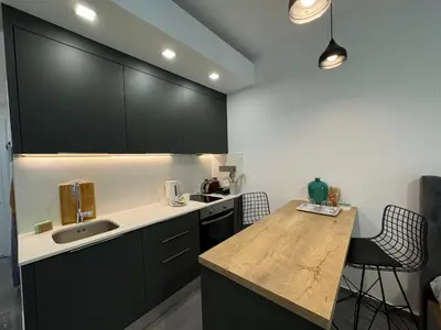 a kitchen with black cabinets and a wooden counter top at Courtyard Holiday Resort Studio in Iskele