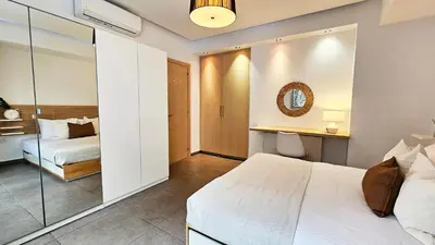 a bedroom with a white bed and a mirror at Phaedrus Living Limassol Ocean Pearl Residence in Limassol