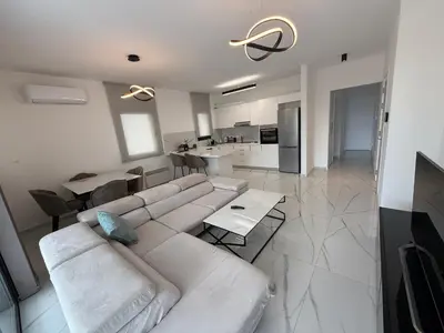 a living room with a white couch and a kitchen at Glabur Stays - Nicosia's Finest 2 Bedroom in Nicosia