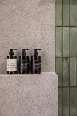 three shampoo bottles sitting on a shelf in a bathroom at Interlace by Holistays in Engomi