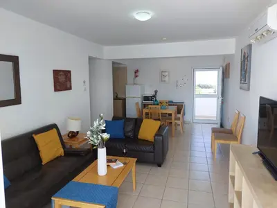 a living room with a couch and a table at Tide Terrace 2 bdr apt in Kapparis, Protaras in Paralimni
