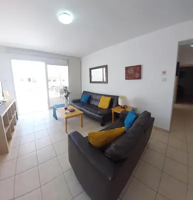 a living room with a couch and a table at Tide Terrace 2 bdr apt in Kapparis, Protaras in Paralimni