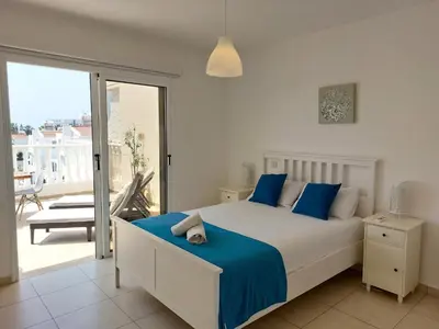 a bedroom with a bed and a balcony at Nissi Retreat - Walk to Nissi beach! in Ayia Napa