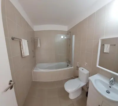 a bathroom with a toilet and a tub and a sink at Nissi Retreat - Walk to Nissi beach! in Ayia Napa