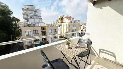 a balcony with a table and chairs and buildings at Seaside Larnaca Makenzie- 50m to Beach in Larnaka