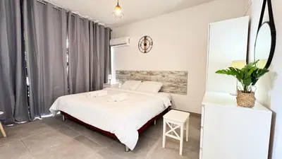 a bedroom with a bed and a mirror at Seaside Larnaca Makenzie- 50m to Beach in Larnaka