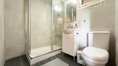 a bathroom with a shower and a toilet and a sink at Seaside Larnaca Makenzie- 50m to Beach in Larnaka