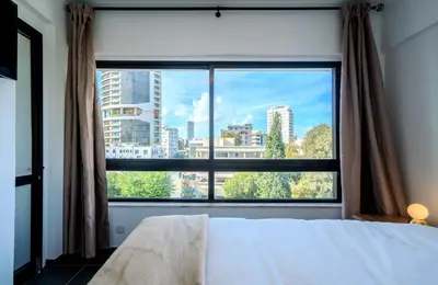 a bedroom with a large window with a view of a city at Element Stays City Suite in Nicosia