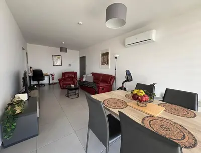 a room with a table and chairs and a living room at Modern 2BR near UNIC & Engomi Mall in Lakatamia