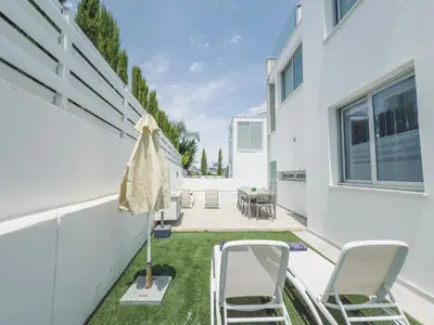 an outdoor patio with chairs and an umbrella at Imperial Jade V4 - Villa Andriana in Protaras in Protaras