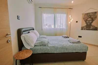 a small bedroom with a bed and a window at Rosam Seaview Holiday apartment in Ayia Napa