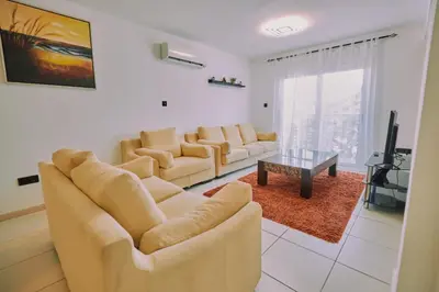 a living room with two couches and a tv at Rosam Seaview Holiday apartment in Ayia Napa