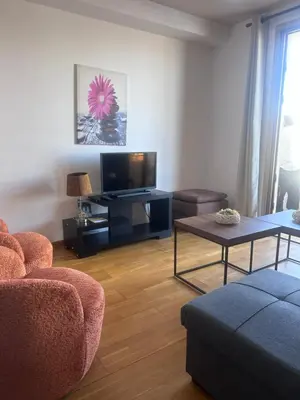 a living room with a tv and a couch and a table at Ithaki Phinikoudes Apartments No. 106 in Larnaka