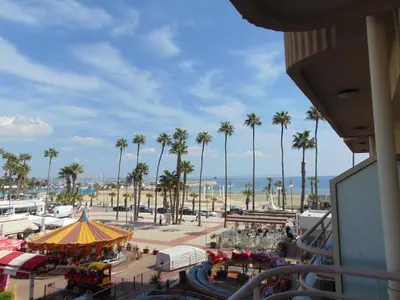 a view of a amusement park with palm trees and the ocean at Ithaki Phinikoudes Apartments No. 106 in Larnaka