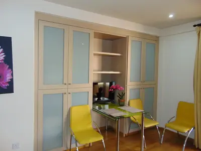 a dining room with a glass table and yellow chairs at Ithaki Phinikoudes Apartment No. 107 in Larnaka