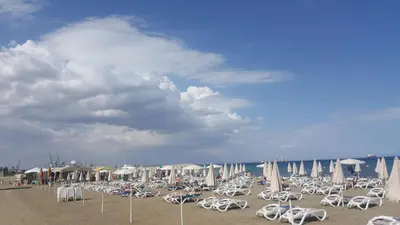 a beach with chairs and umbrellas on the beach at Ithaki Phinikoudes Apartment No. 207 in Larnaka