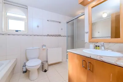 a bathroom with a toilet and a sink and a mirror at Anthorina Greco Villa #18 in Protaras