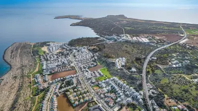 an aerial view of a village on a hill next to the ocean at Anthorina Greco Villa #18 in Protaras