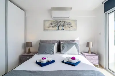 a bedroom with a bed with towels on it at Pervolia Seaview Escape in Pervolia