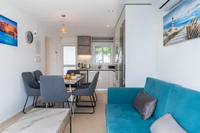 a living room with a blue couch and a table at Pervolia Seaview Escape in Pervolia