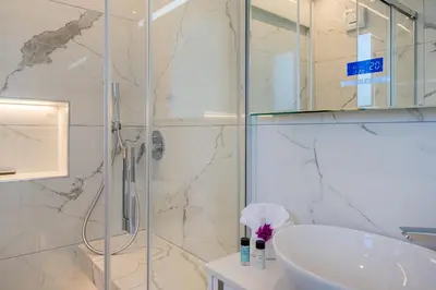 a bathroom with a sink and a glass shower at Pervolia Seaview Escape in Pervolia