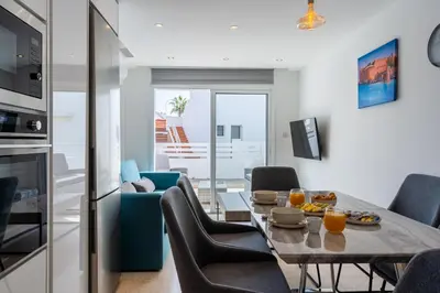 a kitchen and living room with a table and chairs at Pervolia Seaview Escape in Pervolia