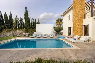 a swimming pool with lounge chairs and a house at villa Ionion H32 in Ayia Napa