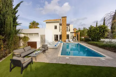 a backyard with a swimming pool and a house at villa Ionion H32 in Ayia Napa