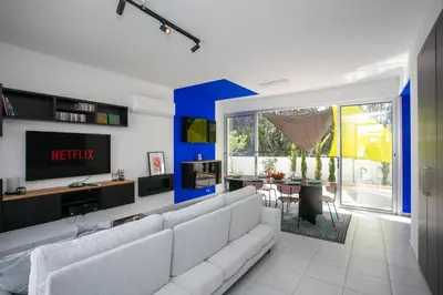 a living room with a white couch and a tv at Palmove Renovated Meneou House in Larnaka