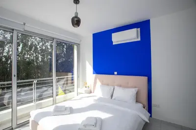 a bedroom with two beds and a blue wall at Palmove Renovated Meneou House in Larnaka