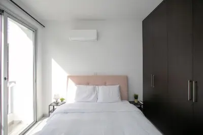 a bedroom with a large bed and a large window at Palmove Renovated Meneou House in Larnaka