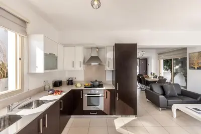 a kitchen and living room with a sink and a couch at villa Palms 31 in Protaras