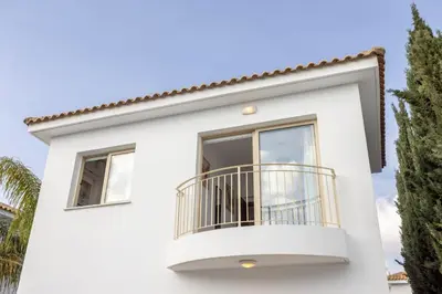 a white house with a balcony at villa Palms 31 in Protaras