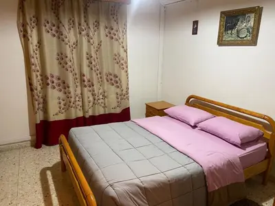 a bedroom with a bed with pink pillows and a curtain at Omodos Village Houses in Omodos