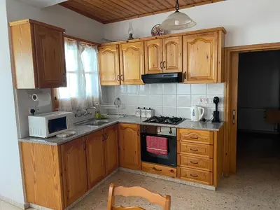 a kitchen with wooden cabinets and a stove top oven at Omodos Village Houses in Omodos