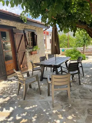 a picnic table with chairs and an umbrella at Omodos Village Houses in Omodos