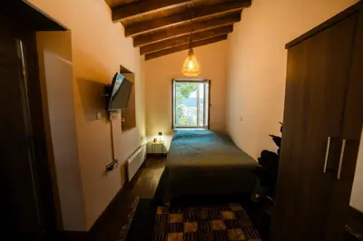a hallway with a bed and a tv and a window at Eftychia's House in Lofou