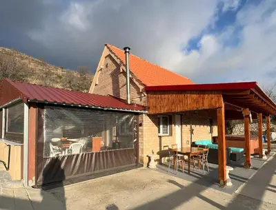 a house with a covered patio with a table at Cherry Holiday House in Khandria