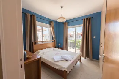 a bedroom with a bed with blue walls and a window at Villa Marina in Ayia Napa