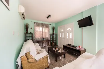 a living room with a white couch and a tv at Villa Marina in Ayia Napa
