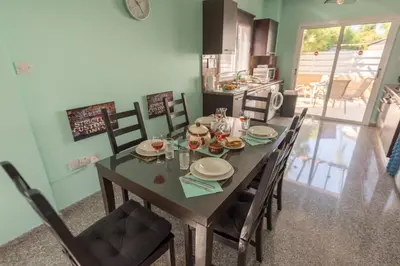 a dining room with a table and chairs in a kitchen at Villa Marina in Ayia Napa