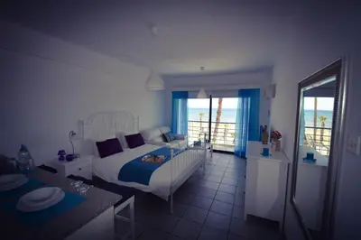 a bedroom with a bed and a view of the ocean at Krasas Beach Apartment Rentals in Larnaka