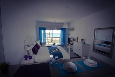a bedroom with a bed and a view of the ocean at Krasas Beach Apartment Rentals in Larnaka