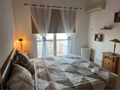 a bedroom with a bed and a large window at Bar street apartment in Ayia Napa