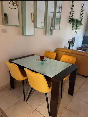 a dining room table with yellow chairs around it at Bar street apartment in Ayia Napa